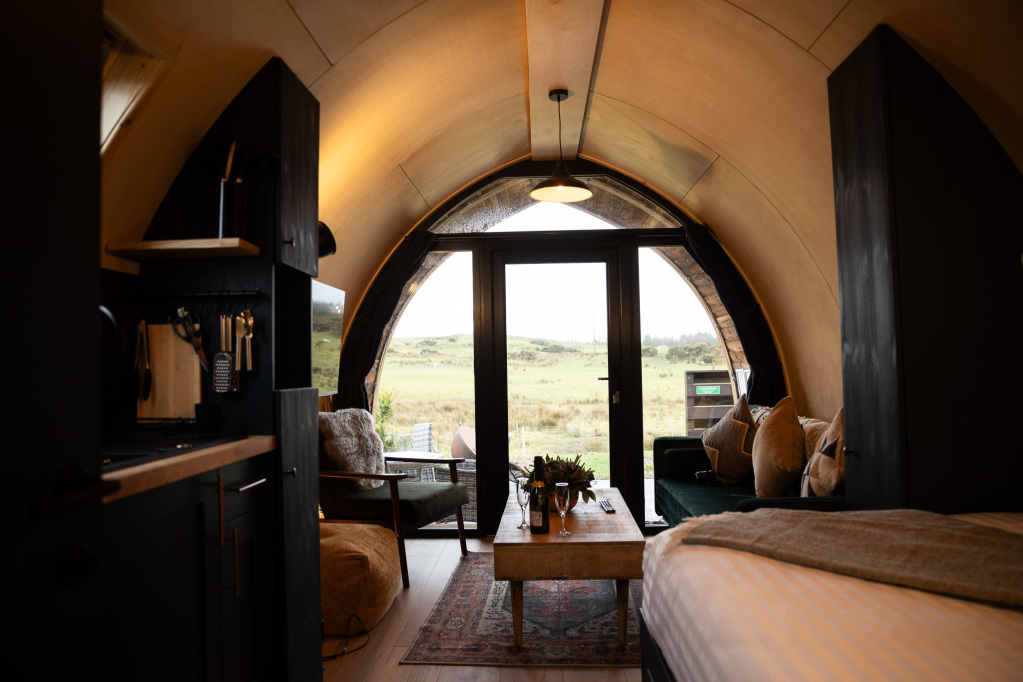 Looking out through a pod’s arched doorway across the fields